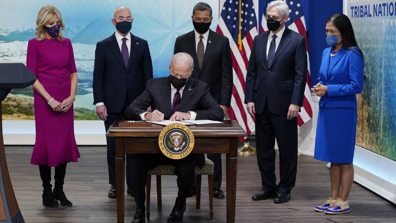 President Joe Biden signs an executive order to help improve public safety and justice for Native Americans during a Tribal Nations Summit during Native American Heritage Month, in the South Court Auditorium on the White House campus, Monday, Nov. 15, 2021, in Washington. With the President from left are first lady Jill Biden, Homeland Security Secretary Alejandro Mayorkas, Health and Human Services Secretary Xavier Becerra, Attorney General Merrick Garland and Interior Secretary Deb Haaland. (AP Photo/Evan Vucci)