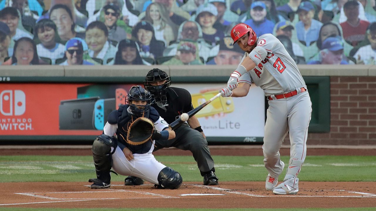 Los Angeles Angels' Mike Trout hits a solo home run during the first inning of a baseball game as Seattle Mariners catcher Austin Nola looks on, Tuesday, Aug. 4, 2020, in Seattle. (AP Photo/Ted S. Warren)