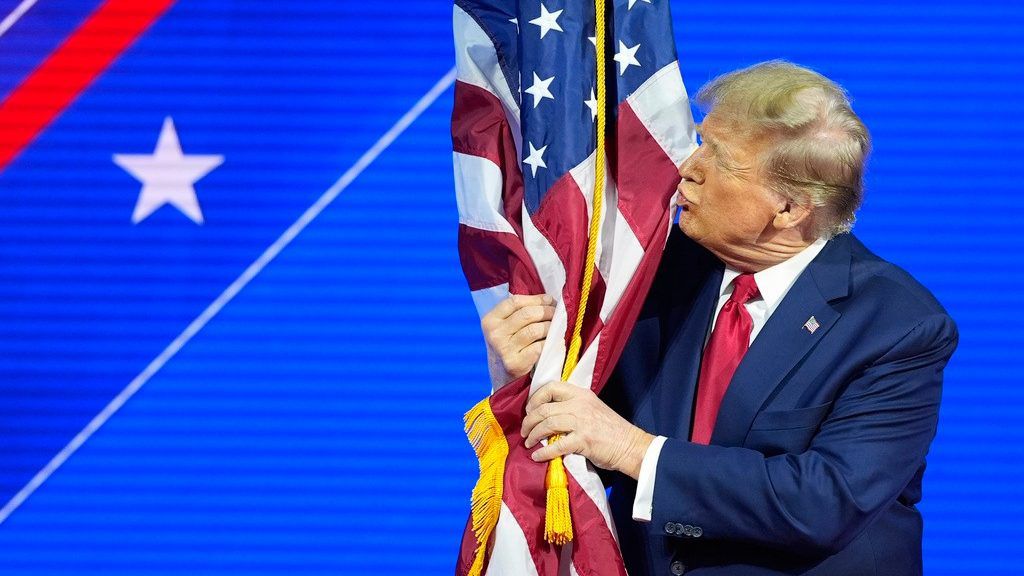 Republican presidential candidate former President Donald Trump hugs and kisses the American flag as he speaks at the Conservative Political Action Conference, CPAC 2024, at National Harbor, in Oxon Hill, Md., Saturday, Feb. 24, 2024. (AP Photo/Alex Brandon)