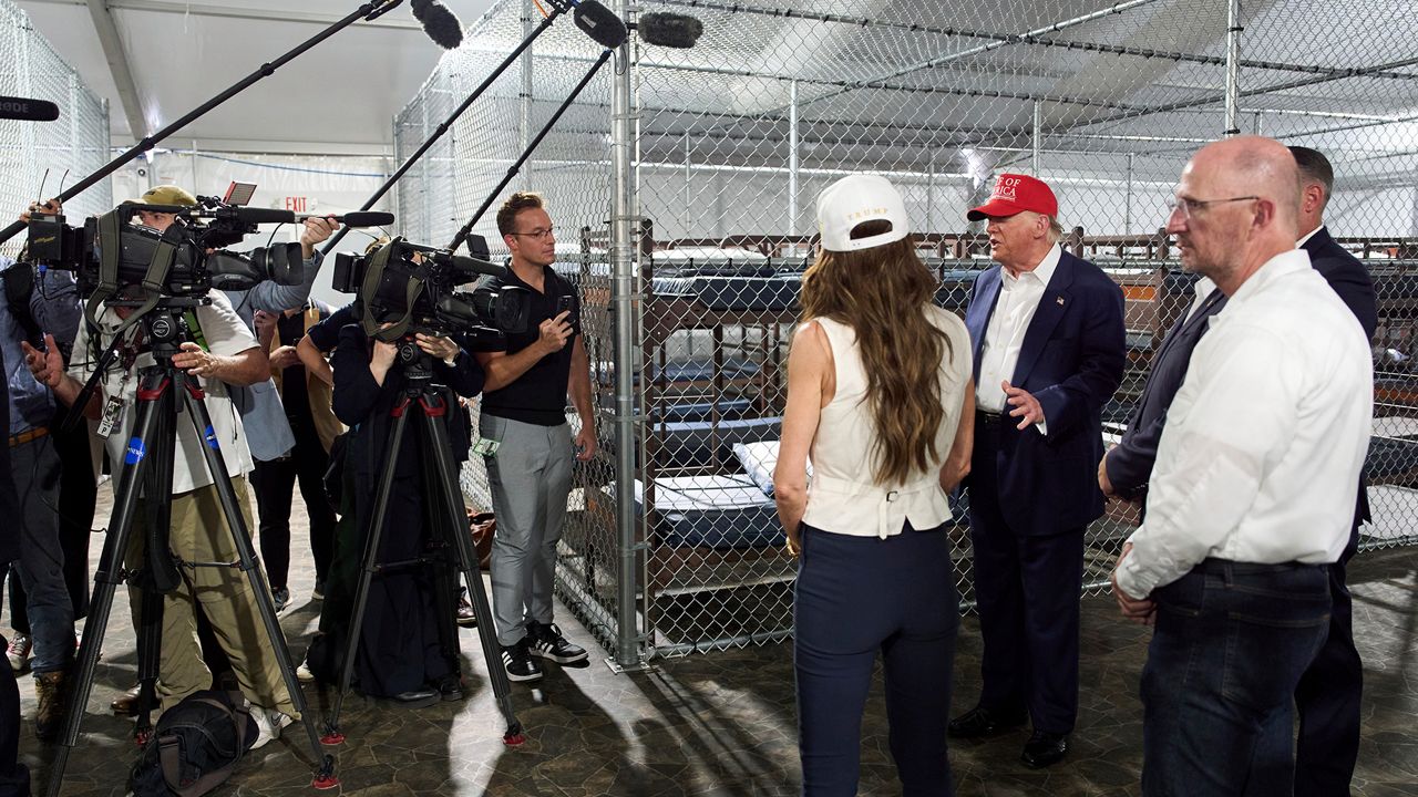 President Donald Trump speaks with reporters as he tours 
