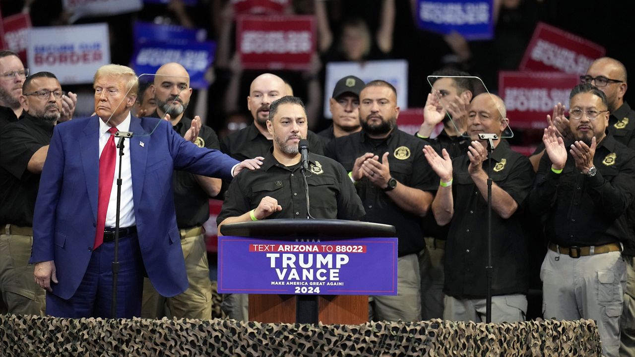 Paul Perez, president of the National Border Patrol Council's Local 3307, speaks as Republican presidential nominee former President Donald Trump listens at a campaign rally at the Findlay Toyota Arena Sunday, Oct. 13, 2024, in Prescott Valley, Ariz. (AP Photo/Ross D. Franklin)