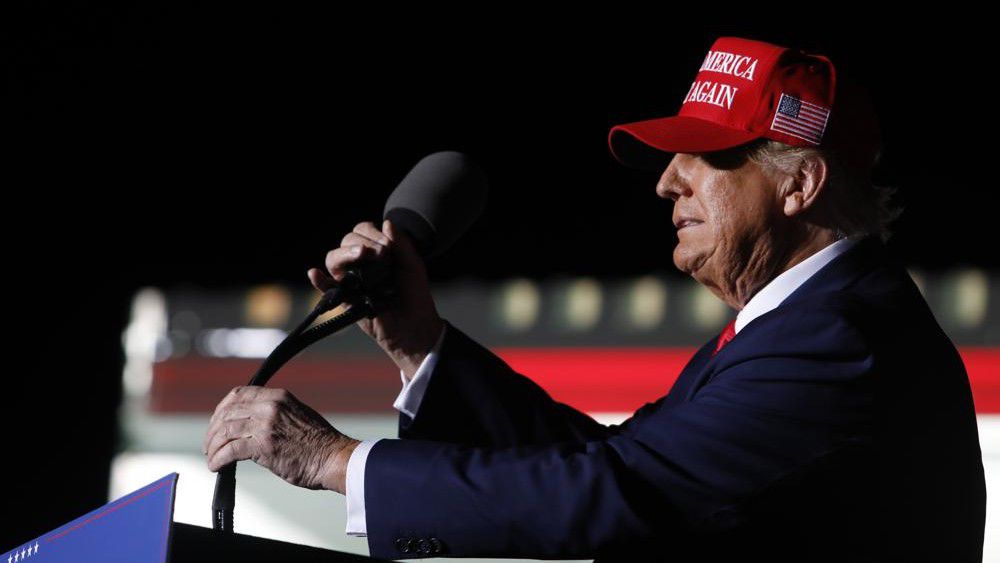 Former President Donald Trump adjusts the microphones after arriving to speak at an election rally in Latrobe, Pa., Saturday, Nov. 5, 2022. (AP Photo/Jacqueline Larma)