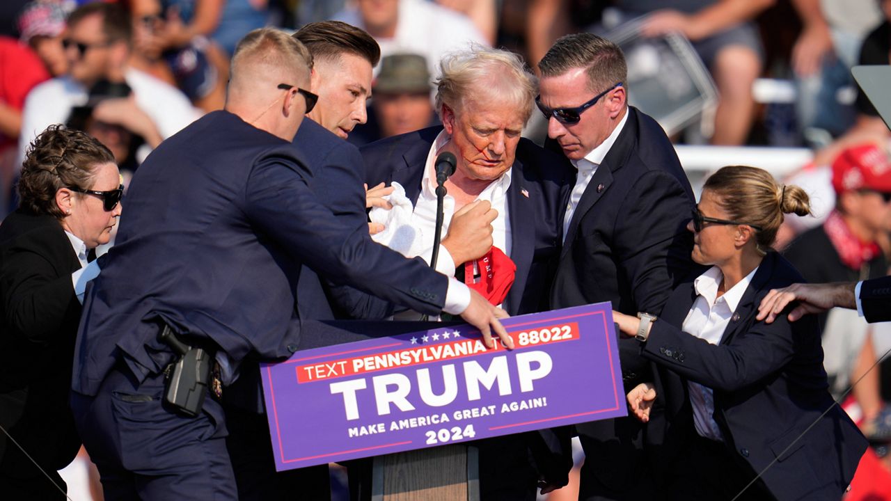 Republican presidential candidate former President Donald Trump is helped off the stage at a campaign event in Butler, Pa., July 13, 2024. (AP Photo/Gene J. Puskar, File)