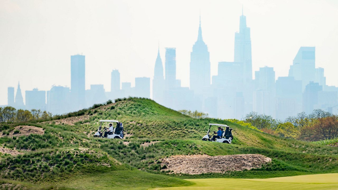 Patrons play the links as the Manhattan skyline is visible in the distance, at Trump Golf Links at Ferry Point in the Bronx borough of New York, May 4, 2021. The New York City-owned golf course, which is managed by former President Donald Trump's business, is expected to host a Saudi Arabia-supported women's tournament in October, city officials said Friday, Aug. 26, 2022. (AP Photo/John Minchillo, File)