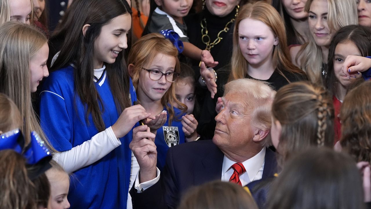 President Donald Trump hands out pens after signing an executive order barring transgender female athletes from competing in women's or girls' sporting events, in the East Room of the White House, Wednesday, Feb. 5, 2025, in Washington. (AP Photo/Alex Brandon)