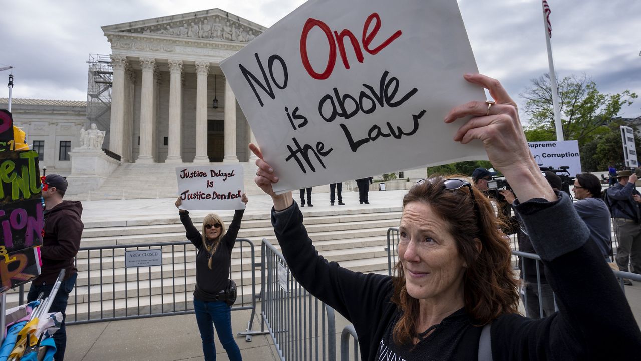 Diana Neary of Minneapolis, joins other protesters demonstrating outside the Supreme Court as the justices hear arguments over whether Donald Trump is immune from prosecution in a case charging him with plotting to overturn the results of the 2020 presidential election, on Capitol Hill in Washington, Thursday, April 25, 2024. (AP Photo/J. Scott Applewhite)