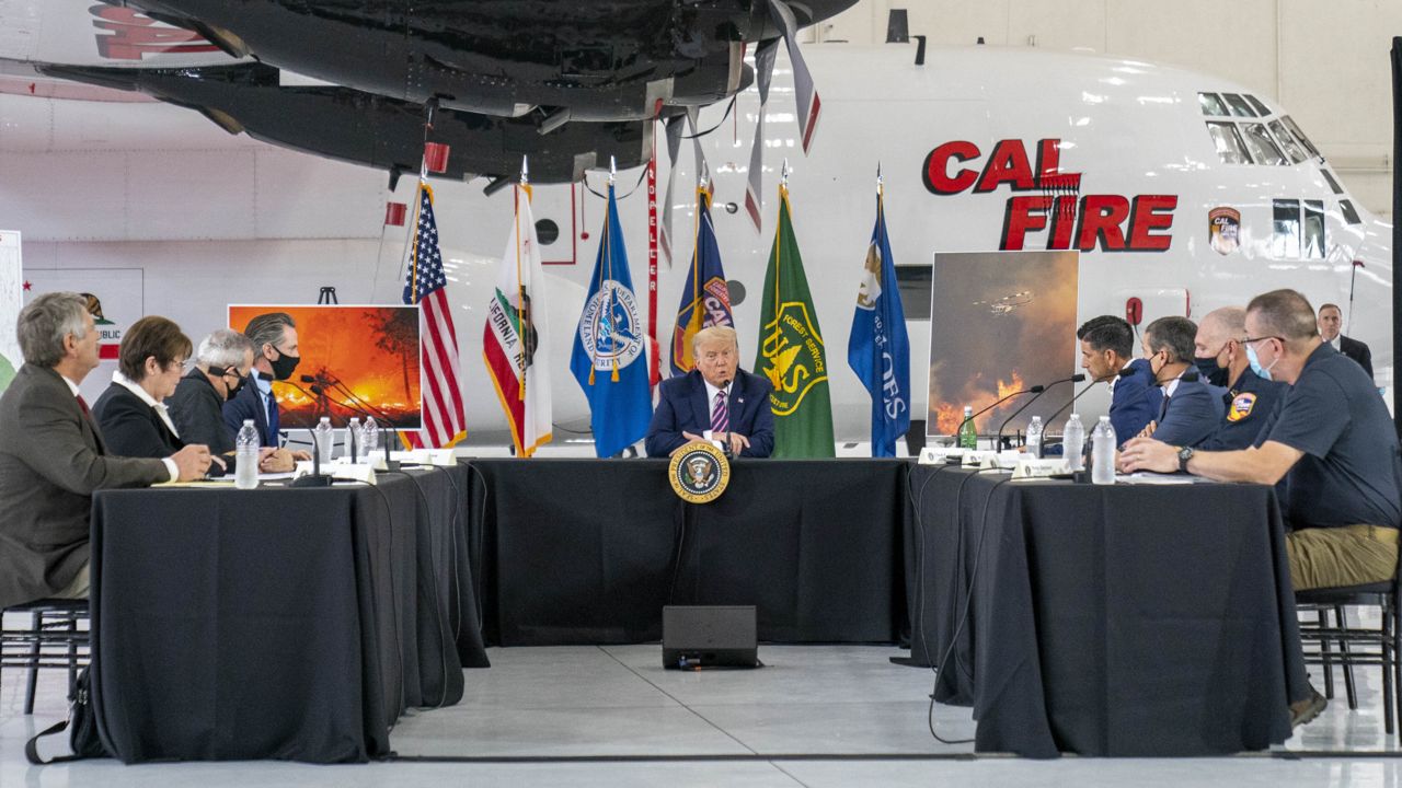 President Donald Trump participates in a briefing on wildfires with Calif. Gov. Gavin Newsom, center left, at Sacramento McClellan Airport, in McClellan Park, Calif., Monday, Sept. 14, 2020. (via Associated Press)