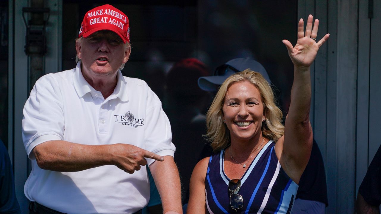 Rep. Marjorie Taylor Greene, R-Ga., waves while former President Donald Trump points to her during the Bedminster Invitational LIV Golf tournament in Bedminster, N.J., on July 30. (AP Photo/Seth Wenig, File)