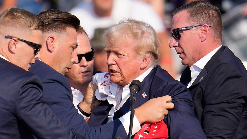 Republican presidential candidate former President Donald Trump is helped off the stage at a campaign event in Butler, Pa., on Saturday, July 13, 2024. (AP Photo/Gene J. Puskar)