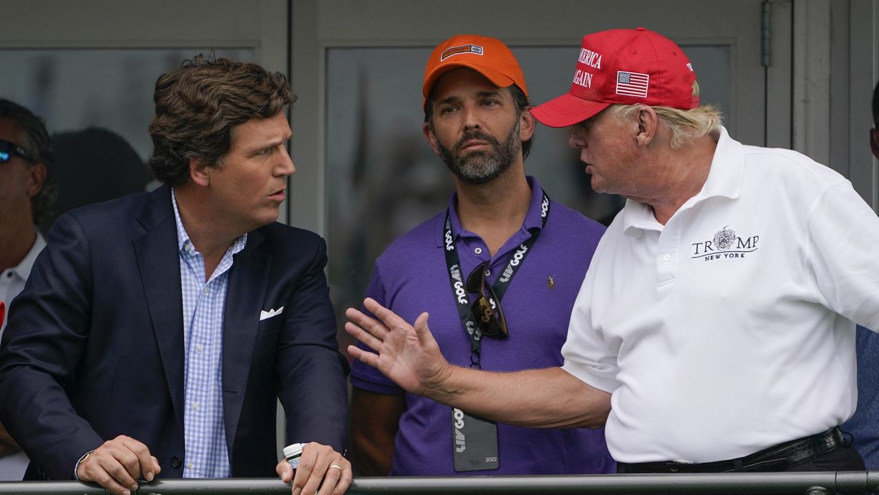 Former President Donald Trump, right, talks with Donald Trump Jr., center, and Tucker Carlson during the Bedminster Invitational LIV Golf tournament in Bedminster, N.J., on July 31, 2022. (AP Photo/Seth Wenig, File)