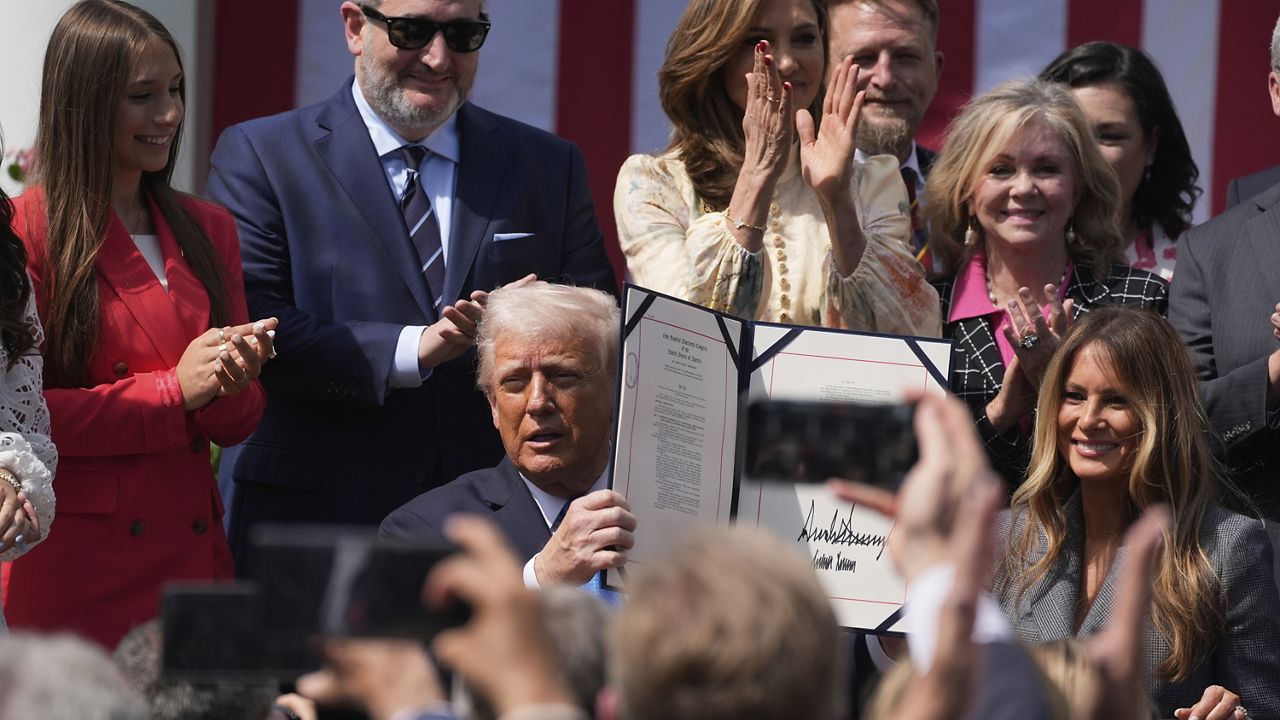 President Donald Trump, with first lady Melania Trump and others, after signing the 