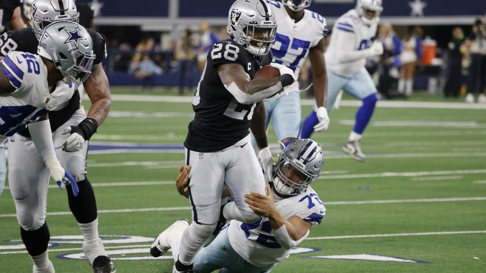 Las Vegas Raiders running back Josh Jacobs (28) picks up a first down running the ball as Dallas Cowboys defensive tackle Trysten Hill (72) helps make the stop in the first half of an NFL football game in Arlington, Texas, Thursday, Nov. 25, 2021. (AP Photo/Michael Ainsworth)