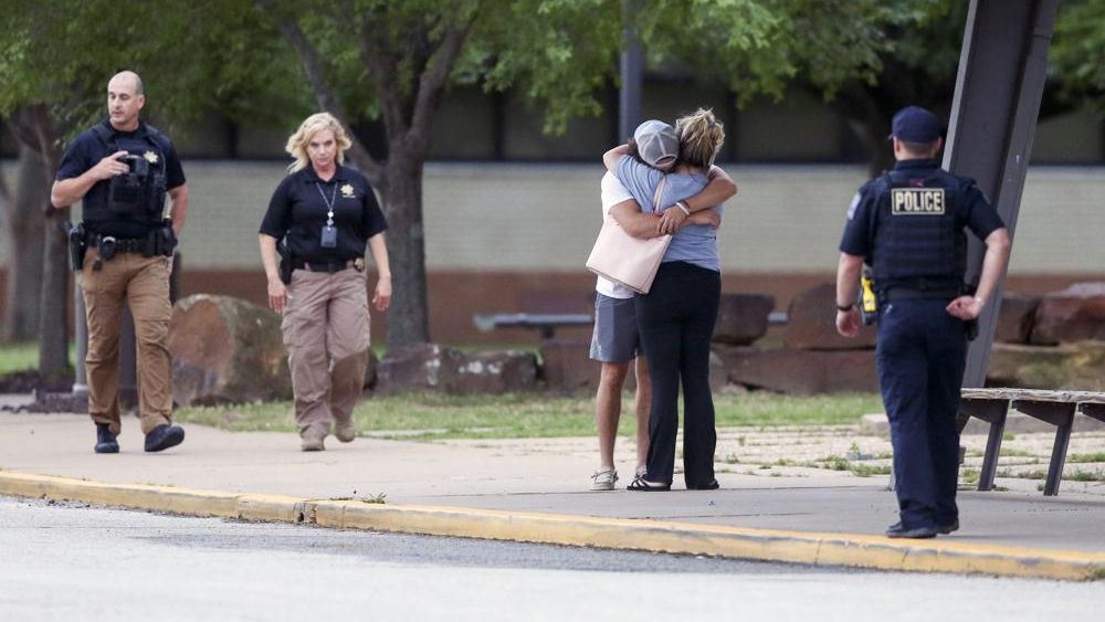 Two people hug outside at Memorial High School where people were evacuated from the scene of a shooting at the Natalie Medical Building Wednesday, June 1, 2022. in Tulsa, Okla. Multiple people were shot at a Tulsa medical building on a hospital campus Wednesday. (Ian Maule/Tulsa World via AP)