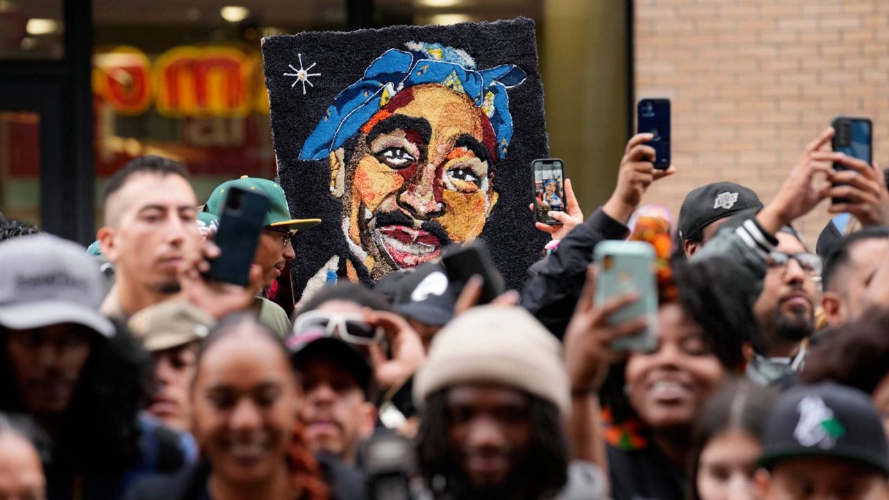 An image of the late rapper and actor Tupac Shakur appears among fans during a ceremony honoring Shakur with a star on the Hollywood Walk of Fame on June 7, 2023, in Los Angeles. (AP Photo/Chris Pizzello)