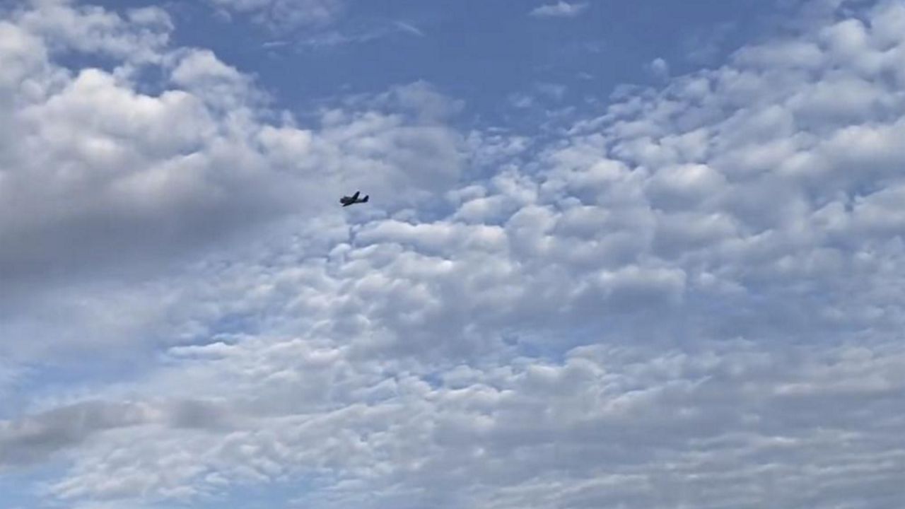 A small airplane circles over Tupelo, Miss., on Saturday, Sept. 3, 2022. Police say the pilot of the small airplane is threatening to crash the aircraft into a Walmart store. The Tupelo Police Department said that the Walmart and a nearby convenience store had been evacuated. (Rachel McWilliams via AP)