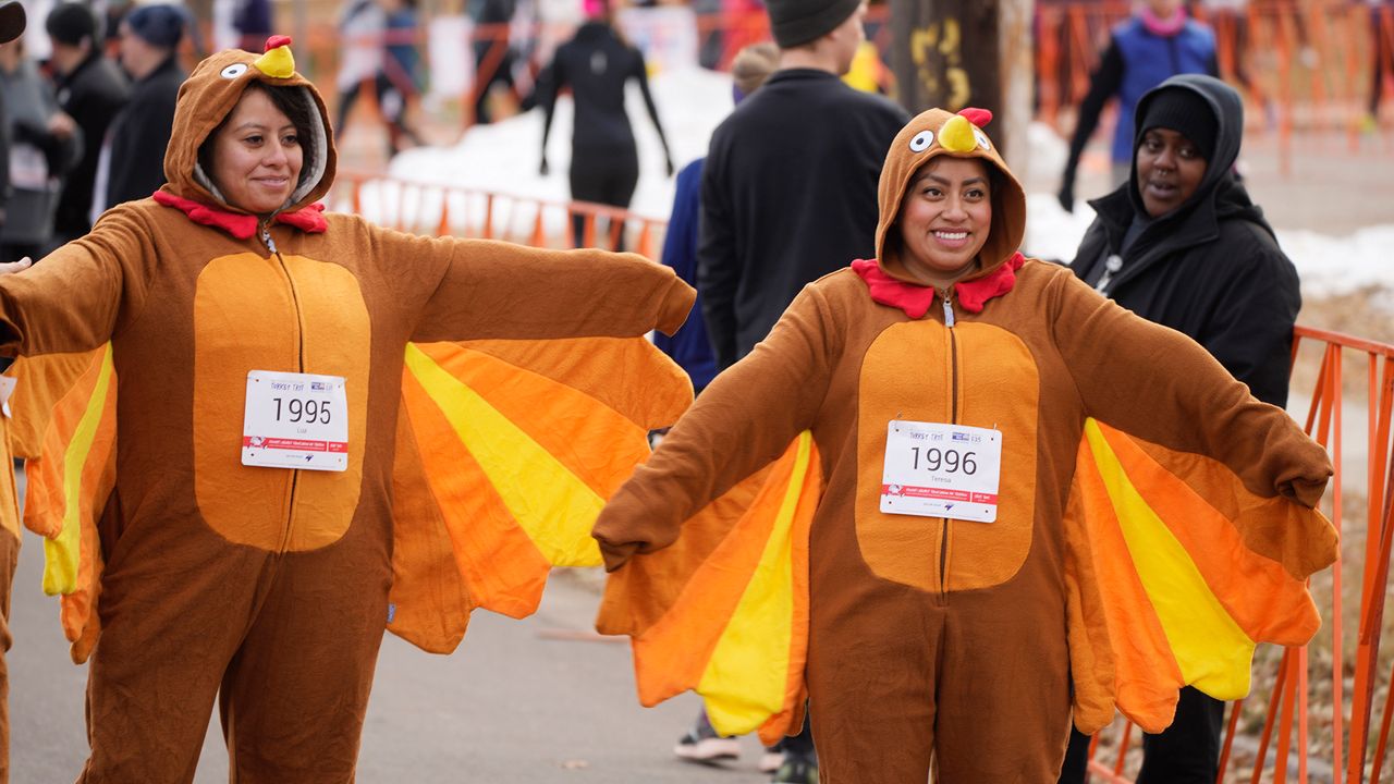 Sisters Luz Duran, left, and Teresa Francisco, both of Denver, spread the wings of their costumes before joining other runners in taking part in the 49th annual Mile High United Way Turkey Trot early Thursday, Nov. 24, 2022, in southeast Denver. (AP Photo/David Zalubowski)