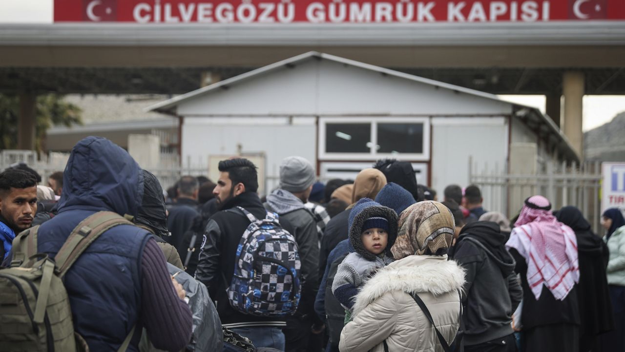 Syrians wait Tuesday to cross into Syria from Turkey at the Cilvegozu border gate, near the town of Antakya, Turkey. (AP Photo/Unal Cam)