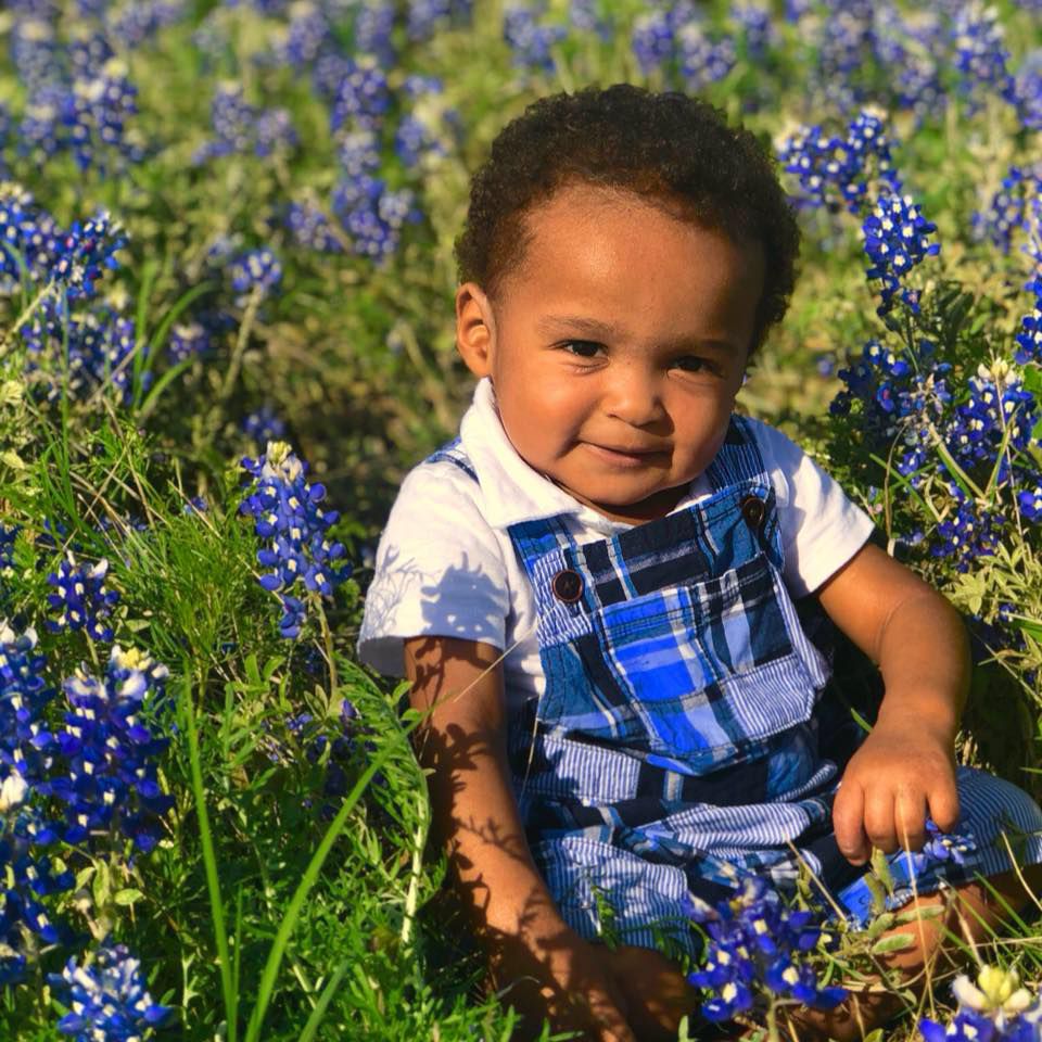Antonio in overalls in the bluebonnets.