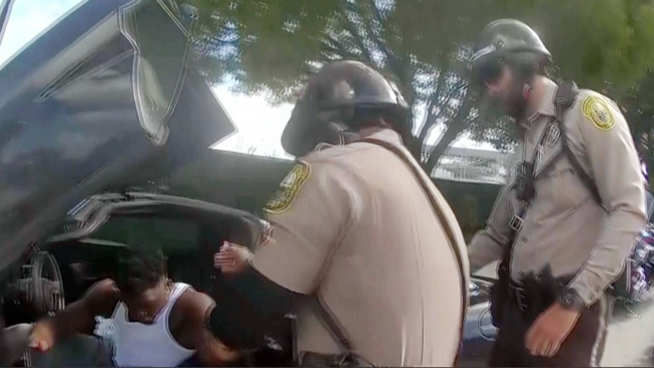 Police body camera video shows an officer dragging Miami Dolphins receiver Tyreek Hill out of his sports car by his arm and head and then forcing him face first onto the ground after Hill put up the window of his vehicle. (Miami-Dade Police Department)