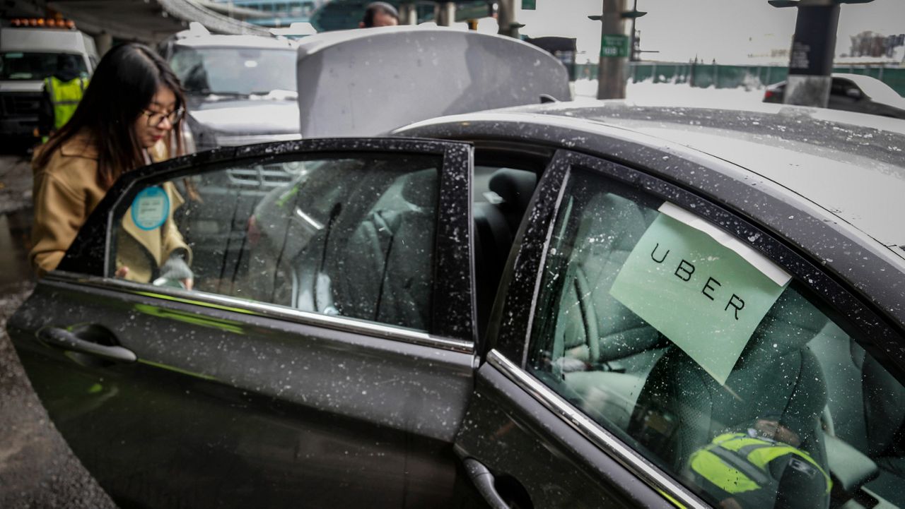 A passenger enters an Uber at LaGuardia Airport in New York on March 15, 2017.