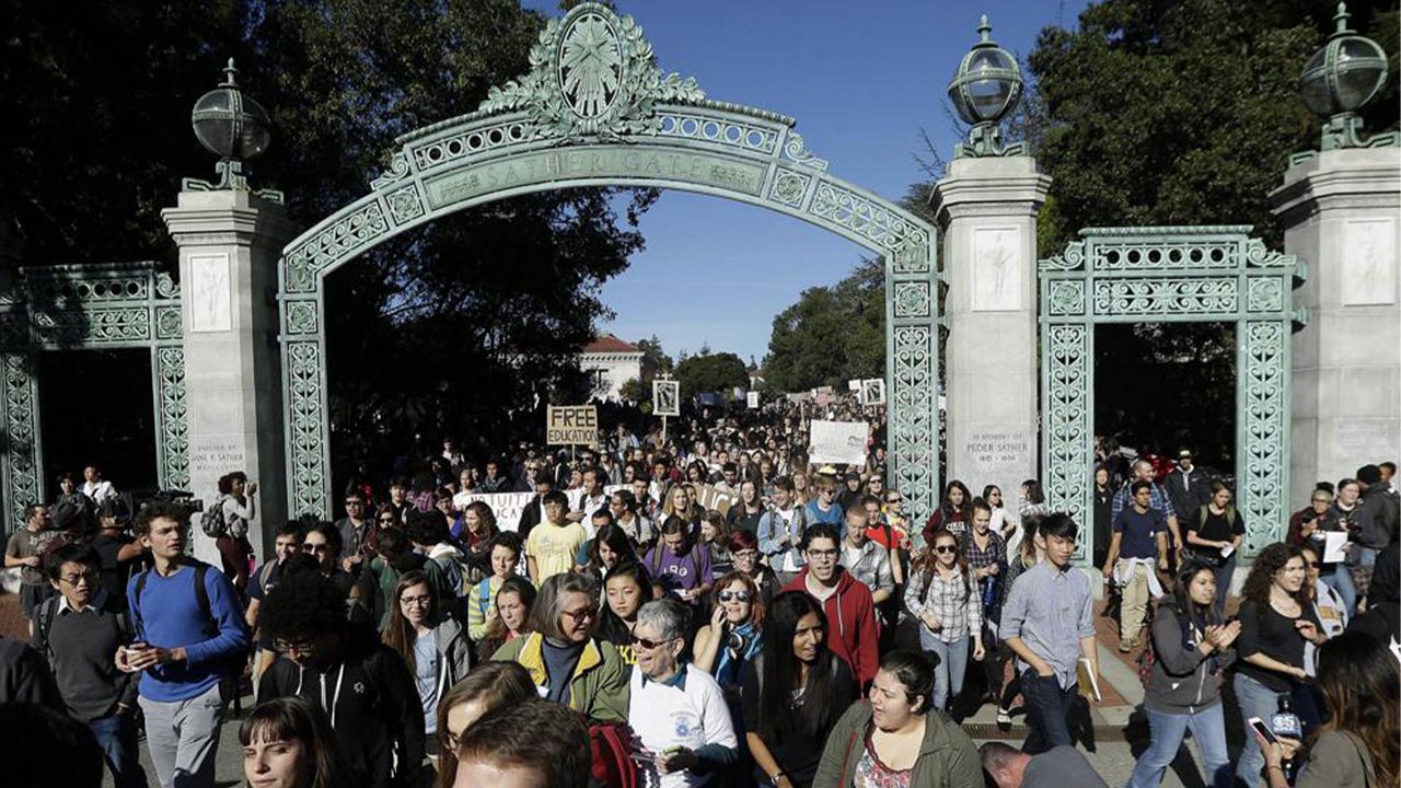 In this Nov. 24, 2014, file photo, students march under Sather Gate during a tuition-hike protest at the University of California in Berkeley, Calif. (AP Photo/Jeff Chiu, File)