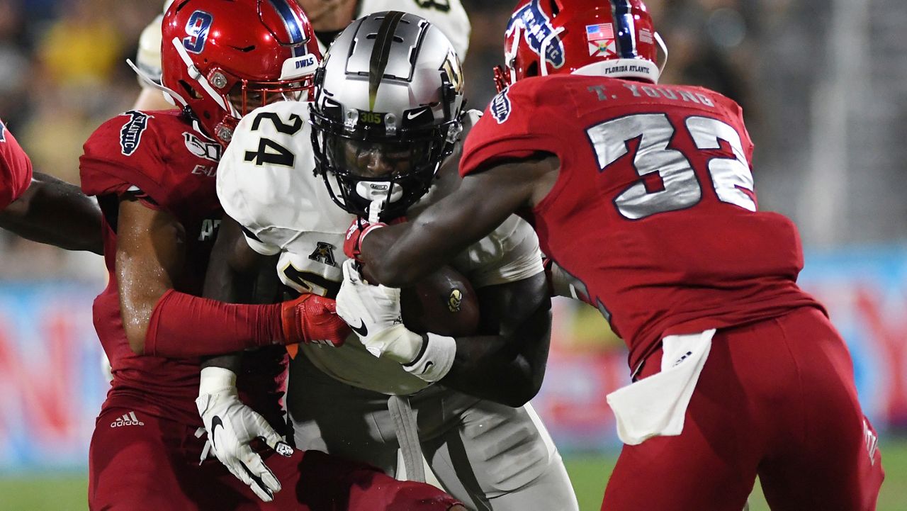 UCF running back Bentavious Thompson (24) battles for a few extra yards as Florida Atlantic safety Quran Hafiz (9) closes in for the tackle during the second half of an NCAA college football game Saturday, Sept. 7, 2019, in Boca Raton, Fla. (AP Photo/Jim Rassol)