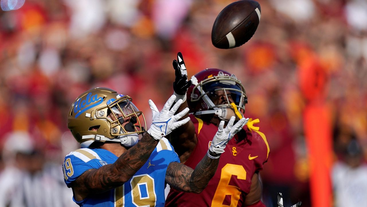 UCLA running back Kazmeir Allen, left, makes a touchdown catch as Southern California cornerback Isaac Taylor-Stuart defends during the first half of an NCAA college football game Saturday, Nov. 20, 2021, in Los Angeles. (AP Photo/Mark J. Terrill)