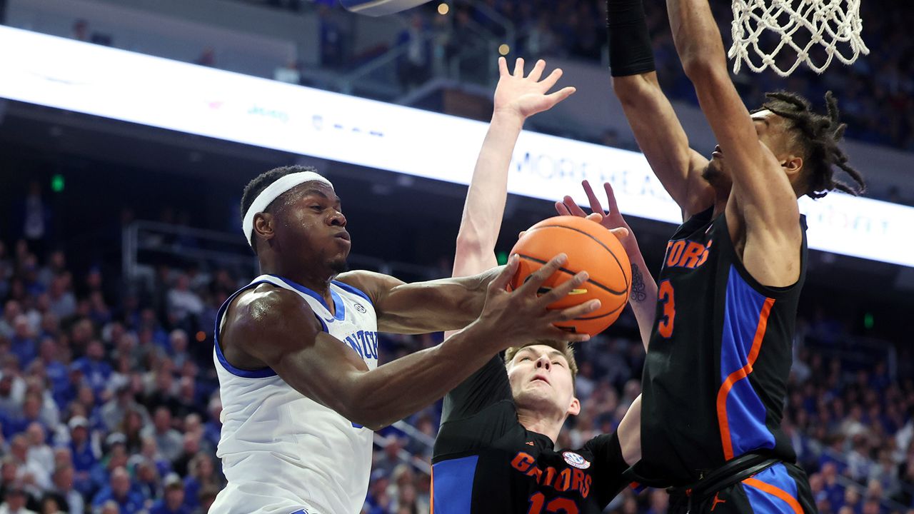 Kentucky's Oscar Tshiebwe (34) shoots while defended by Florida's Colin Castleton (12) and Alex Fudge (3) during the first half of an NCAA college basketball game in Lexington, Ky., Saturday, Feb. 4, 2023. (AP Photo/James Crisp)