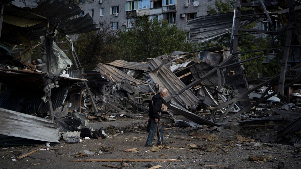 An elderly man walks Tuesday past a car shop that was destroyed after a Russian attack in Zaporizhzhia, Ukraine. (AP Photo/Leo Correa)
