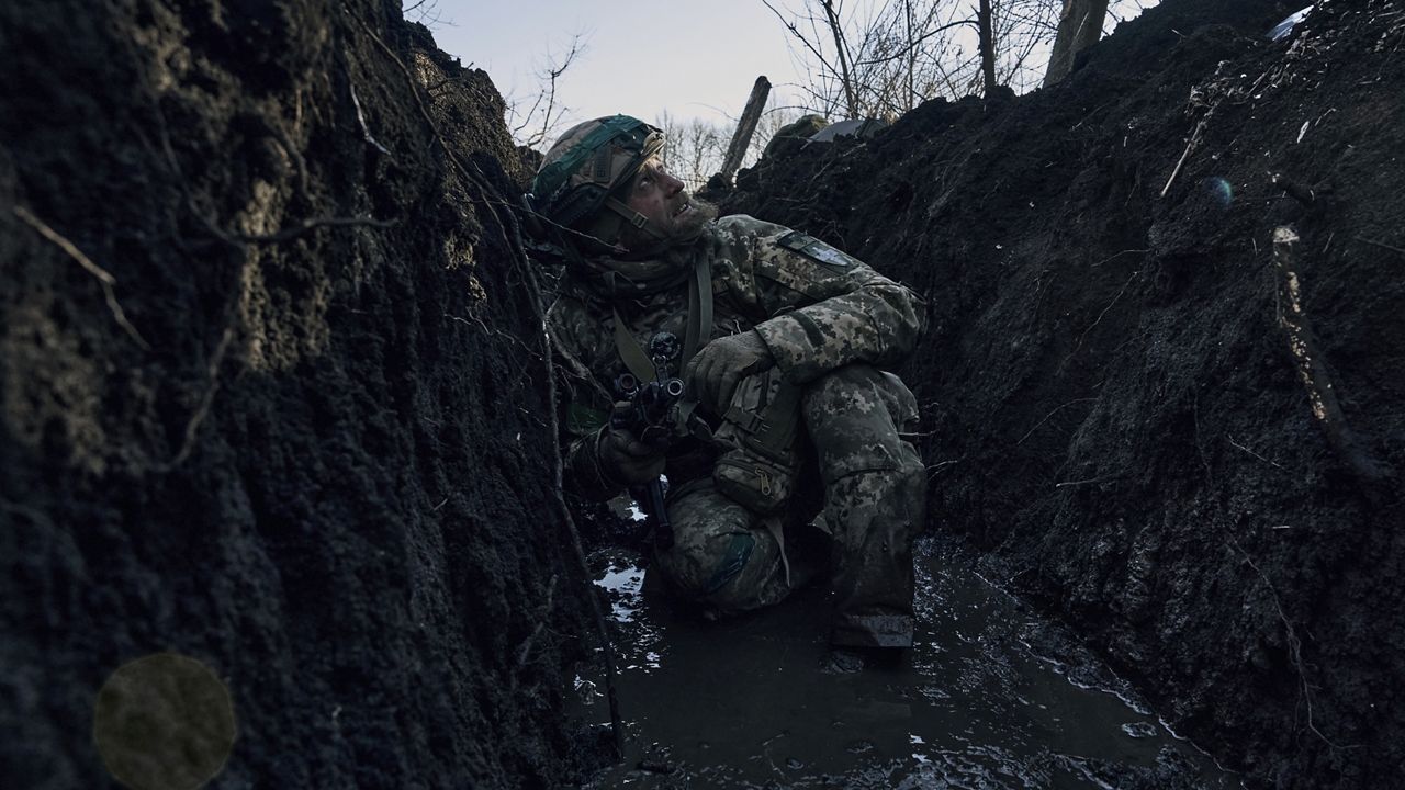 A Ukrainian soldier takes cover Sunday in a trench under Russian shelling on the frontline close to Bakhmut, Ukraine. (AP Photo/Libkos)