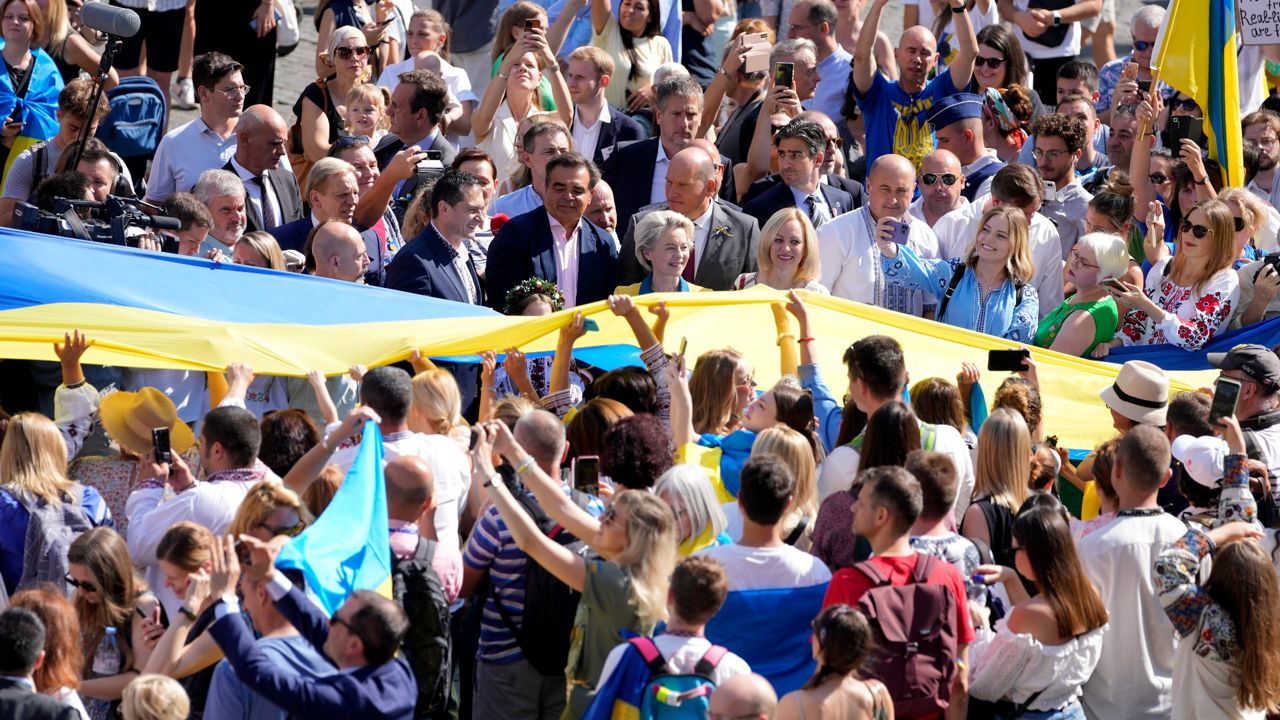 European Commission President Ursula von der Leyen, center, marches Wednesday alongside a giant Ukrainian flag unfurled during an event for Ukrainian Independence Day in Brussels (AP Photo/Virginia Mayo)