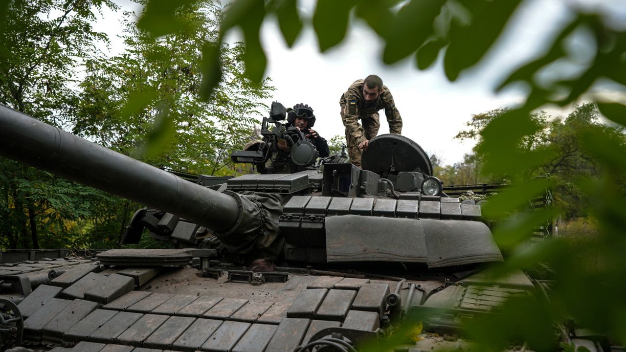 Ukrainian servicemen sit Tuesday on T-80 tank that they claimed had been captured from the Russian army in Bakhmut, Ukraine. (AP Photo/Inna Varenytsia)