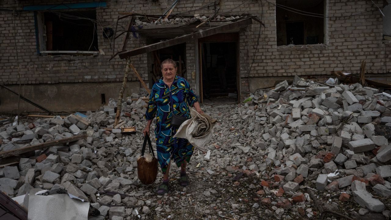 A woman salvages what she can from her home Sunday after a rocket hit an apartment residential block in Chasiv Yar, in the Donetsk region of eastern Ukraine. (AP Photo/Nariman El-Mofty)