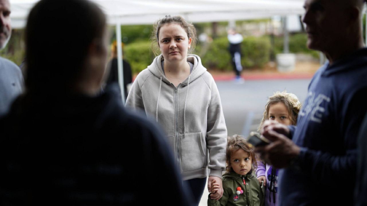 A Ukrainian family arrives at a shelter at the Christian church Calvary San Diego for Ukrainians arriving after crossing into the United States from Tijuana, Mexico, Friday, April 1, 2022, in Chula Vista, Calif.  (AP Photo/Gregory Bull)