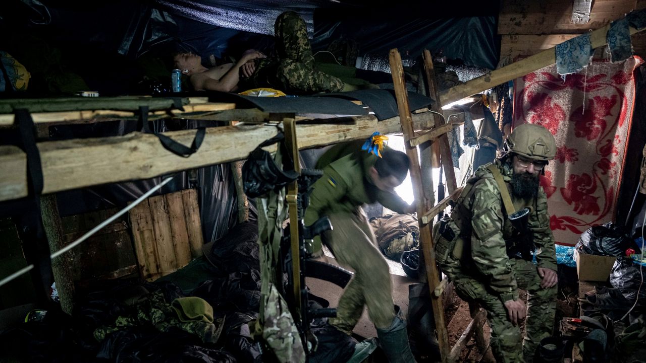 Ukrainian paratroopers rest inside a dugout at the front line near Bakhmut, Ukraine, on Friday, March 10, 2023. (AP Photo/Evgeniy Maloletka)