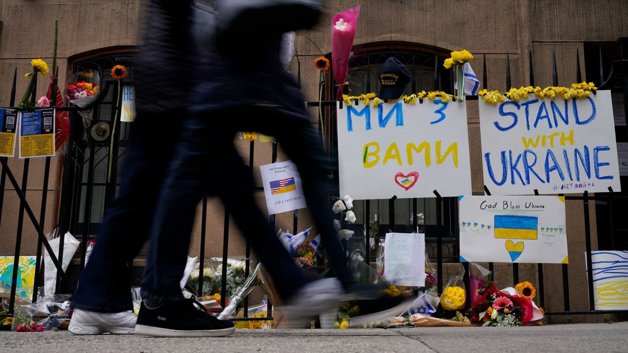 Signs and flowers of support adorn the gates of the Ukrainian Mission to the United Nations in New York, Tuesday, March 1, 2022.