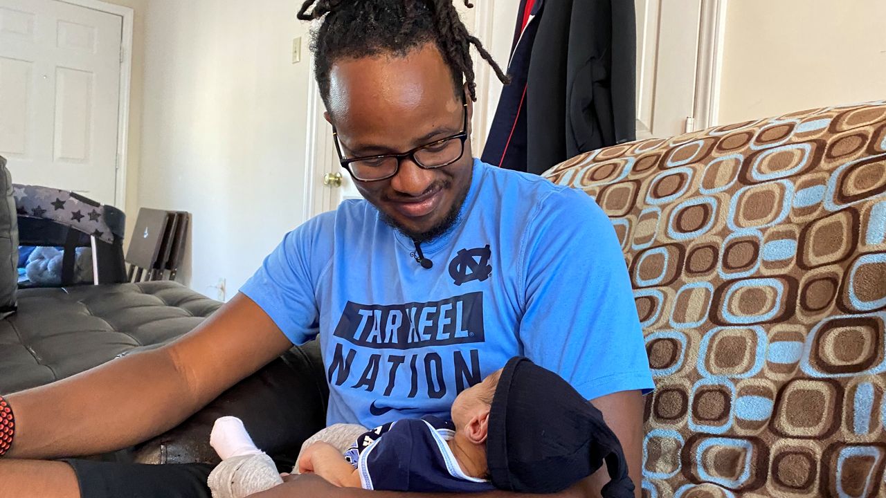 Demar Ellis, Sr. is holding his son Demar Ellis, Jr.