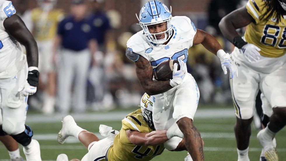 North Carolina running back Omarion Hampton (28) tries to escape from Georgia Tech linebacker Kyle Efford (44) during the first half of an NCAA college football game, Saturday, Oct. 28, 2023, in Atlanta. (AP Photo/John Bzemore)