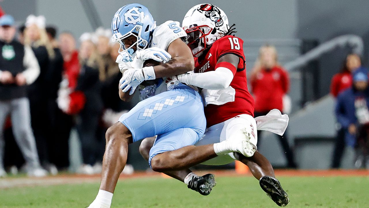 North Carolina wide receiver J.J. Jones (5) is tackled by North Carolina State safety Bishop Fitzgerald (19) after a long reception during the first half of an NCAA college football game in Raleigh, N.C., Saturday, Nov. 25, 2023. (AP Photo/Karl B DeBlaker)