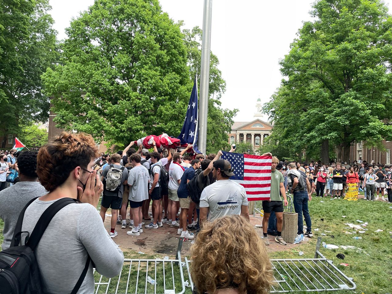 Counterprotestors hold up the American flag while surrounded by Pro-Palestinian protestors (Spectrum News 1/Sophia Fanning)