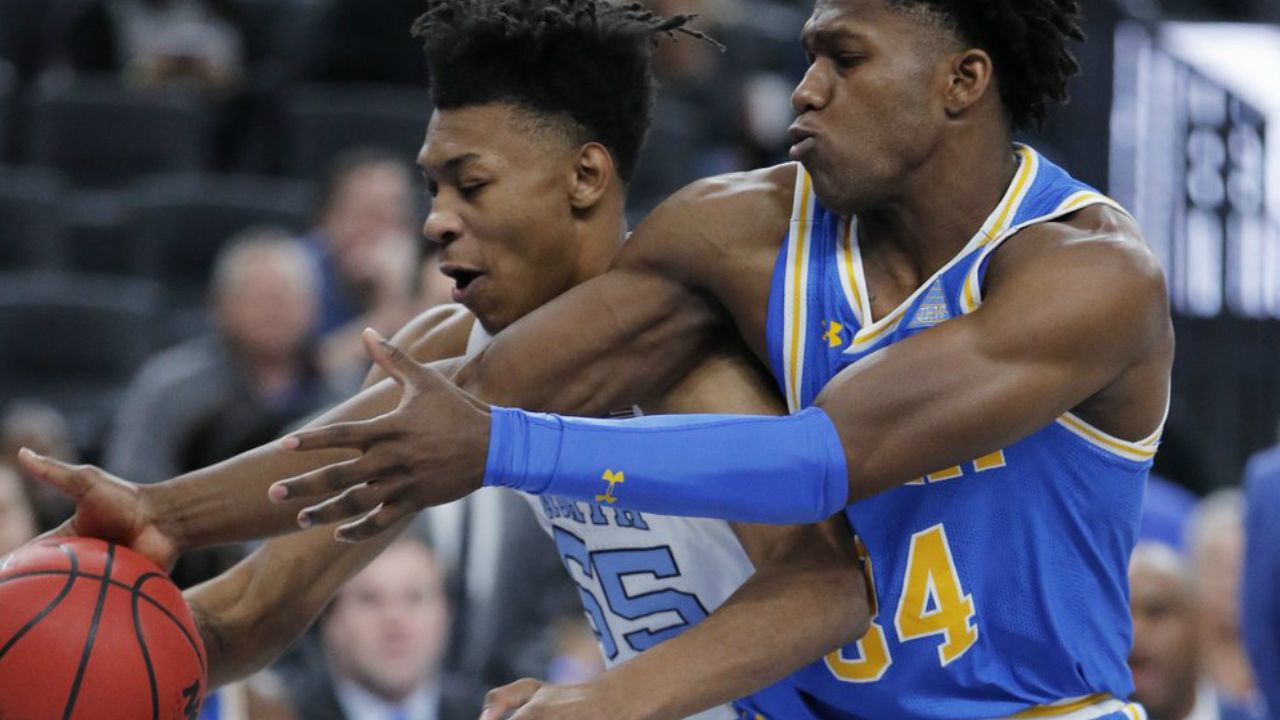 North Carolina's Christian Keeling, left, and UCLA's David Singleton battle for the ball during the first half of an NCAA college basketball game Saturday, Dec. 21, 2019, in Las Vegas.