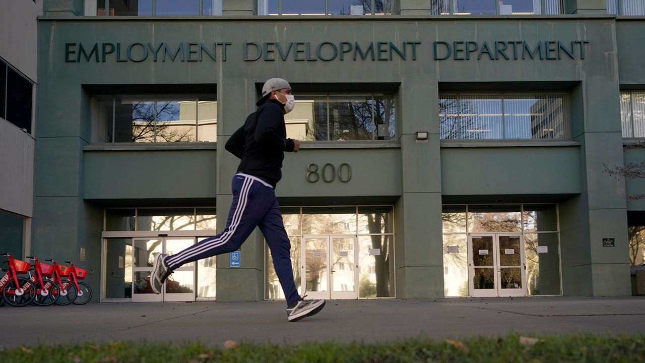 In his Dec. 18, 2020 file photo a runner passes the office of the California Employment Development Department in Sacramento, Calif. (AP Photo/Rich Pedroncelli, File)