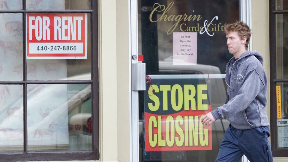 A person walks past a closed card and gift shop in this file image. (Associated Press)