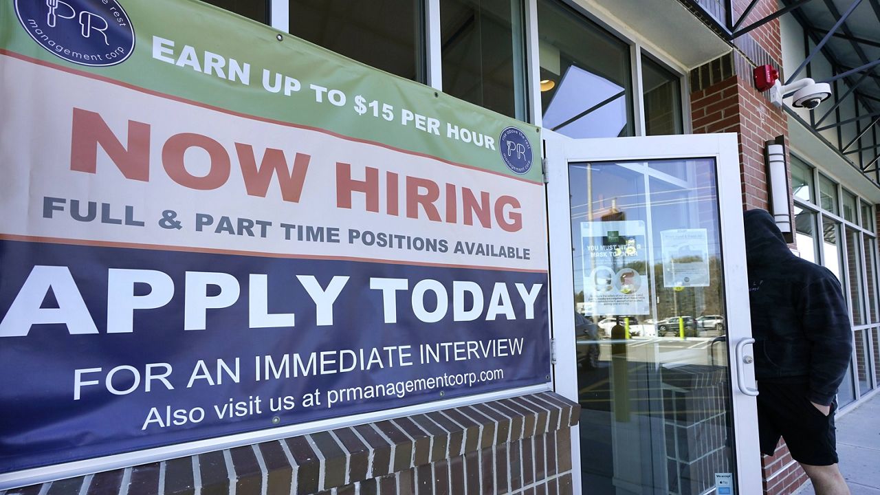 A man walks into a restaurant displaying a "now hiring" sign on March 4 in Salem, N.H. (AP Photo/Elise Amendola)