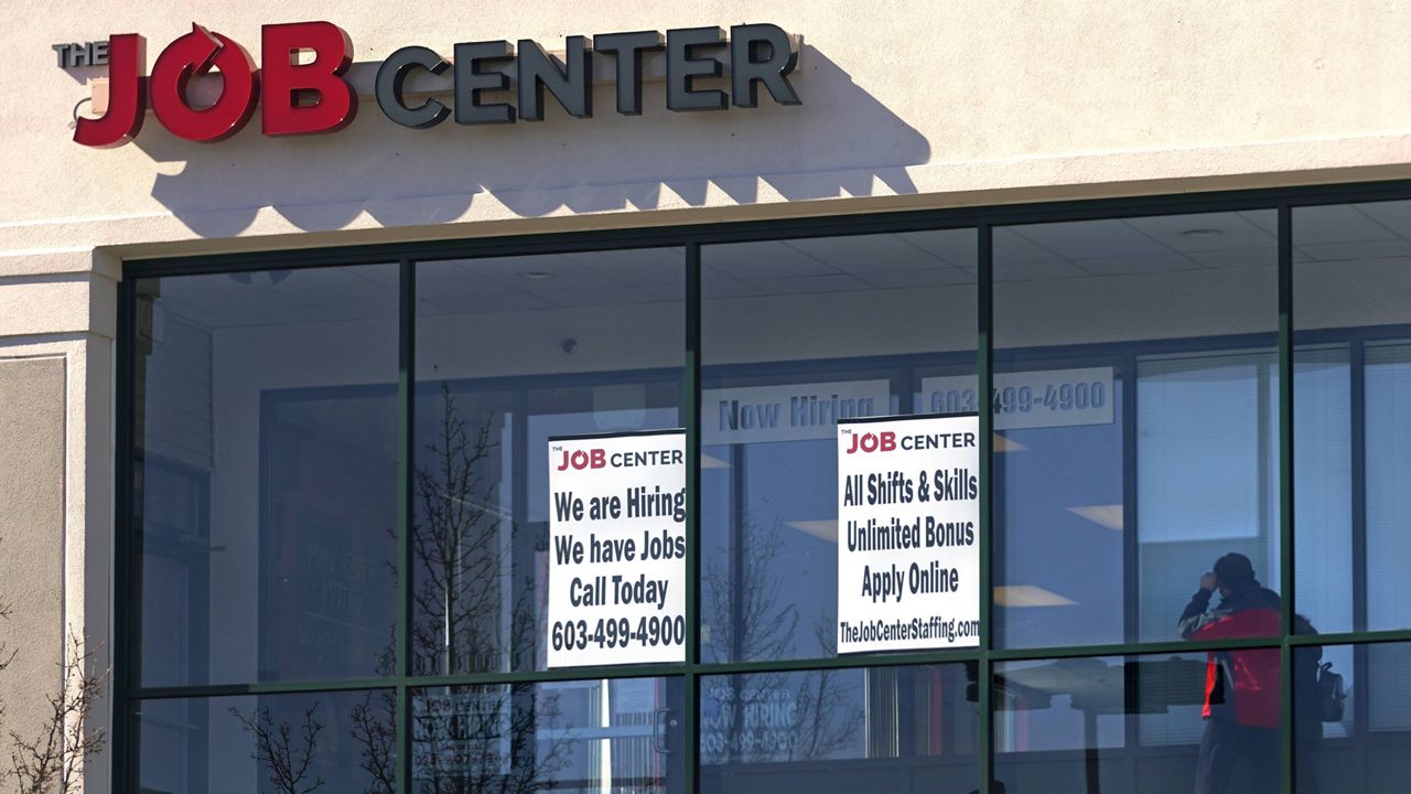 A man walks past the signs of an employment agency in Manchester, N.H., on March 2. (AP Photo/Charles Krupa)