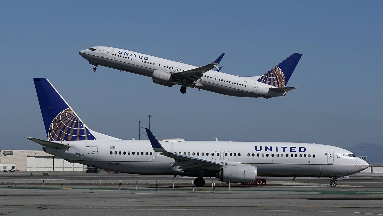 A United Airlines airplane takes off over a plane on the runway at San Francisco International Airport in San Francisco. (AP Photo/Jeff Chiu, File)