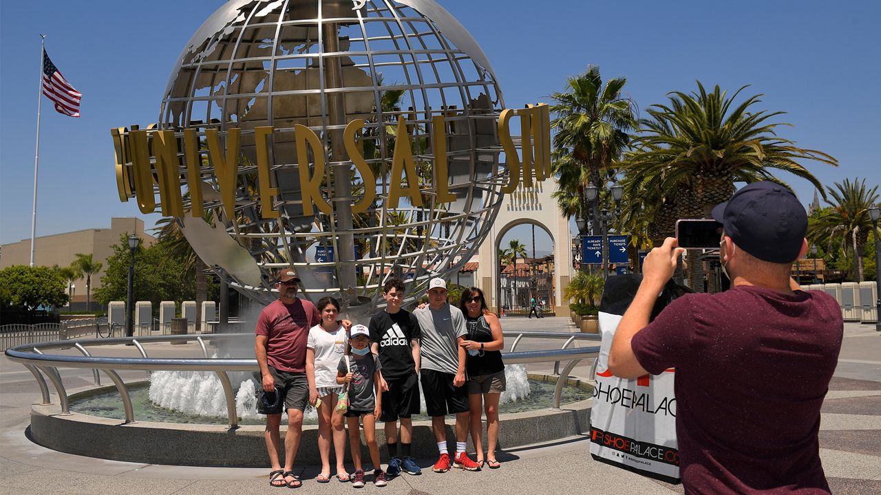 A family has their picture taken at Universal CityWalk, Thursday, June 11, 2020, near Universal City, Calif. (AP Photo/Mark J. Terrill)