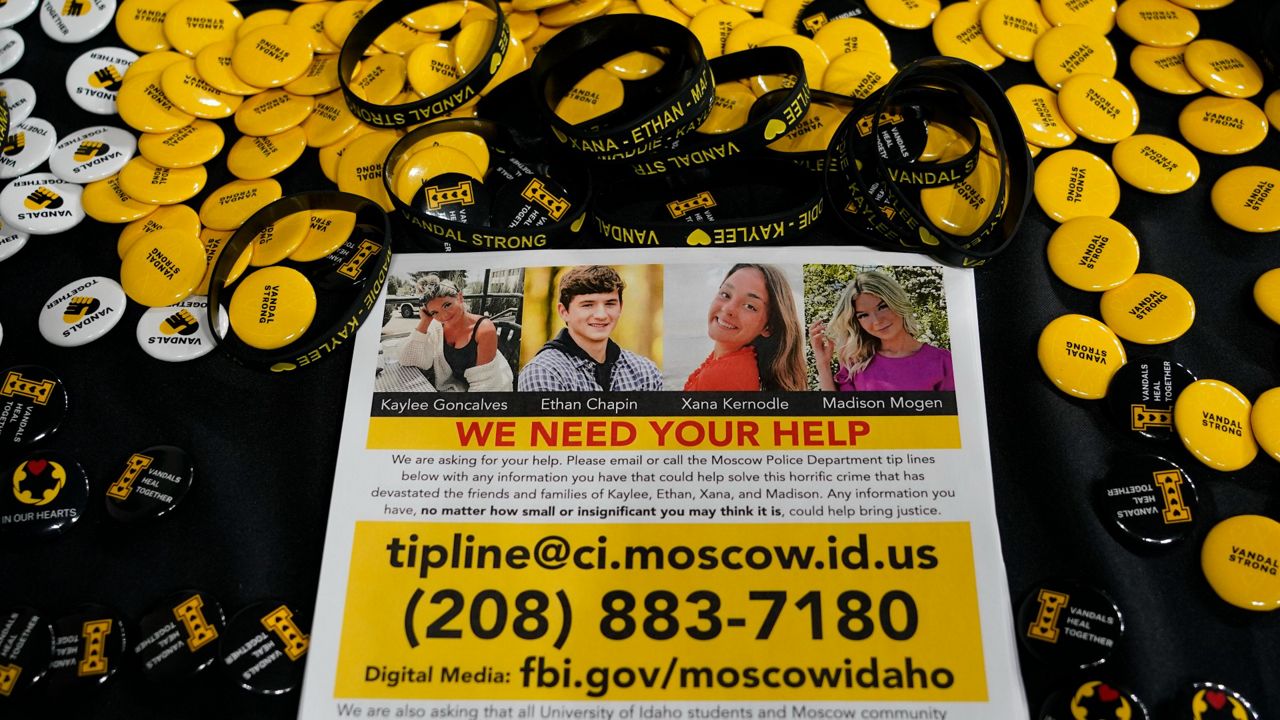 A flyer seeking information about the killings of four University of Idaho students is displayed on a table along with buttons and bracelets on Nov. 30, 2022, during a vigil in memory of the victims in Moscow, Idaho. (AP Photo/Ted S. Warren, File)