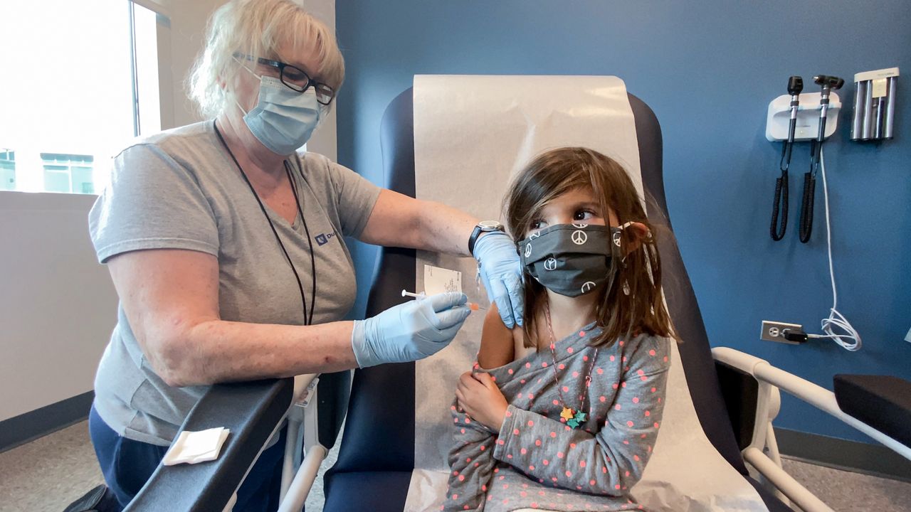 Bridgette Melo, 5, with her father, received a vaccine during the pediatric trials held at Duke.