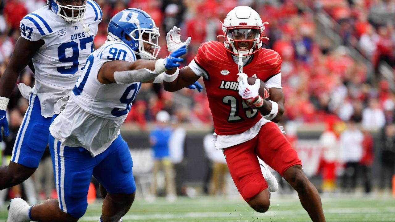 Louisville running back Jawhar Jordan (25) attempts to avoid the defense of Duke defensive tackle DeWayne Carter (90) during the first half of an NCAA college football game in Louisville